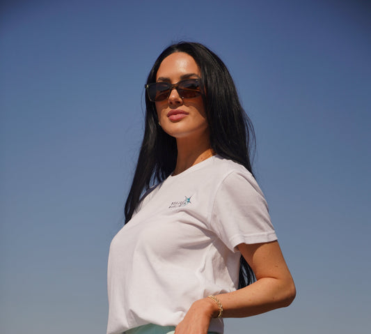 Woman standing outdoors with a clear blue sky and ocean background